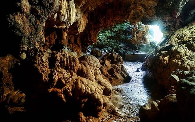 Limestone formations and a stream inside a Meghalaya cave
