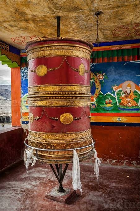 A large painted prayer wheel inside a Ladakhi monastery
