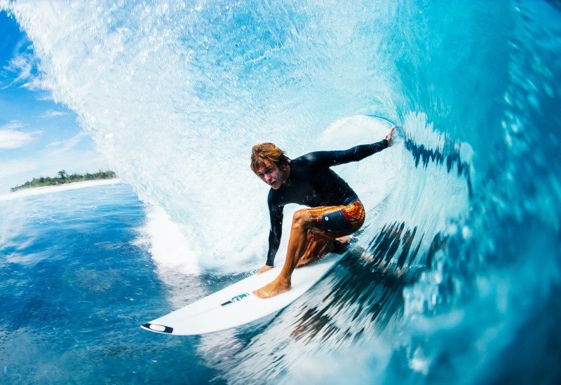 A surfer riding inside a breaking wave