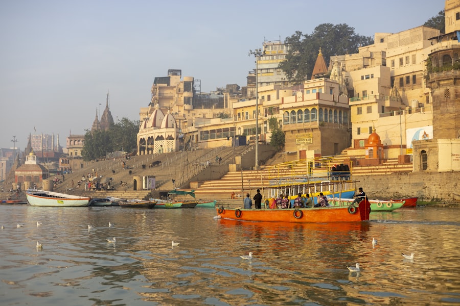 The lamp-lit ghats of Varanasi rising from the Ganga at dusk, a city built onto the river.